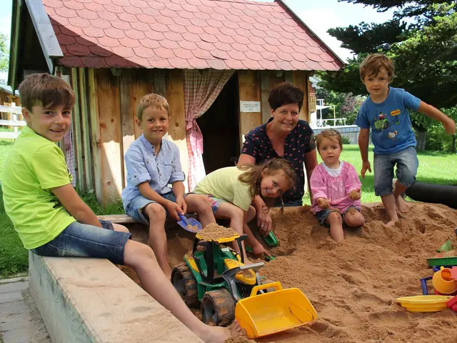 Kinder sitzen am Rand des Sandkastens und spielen