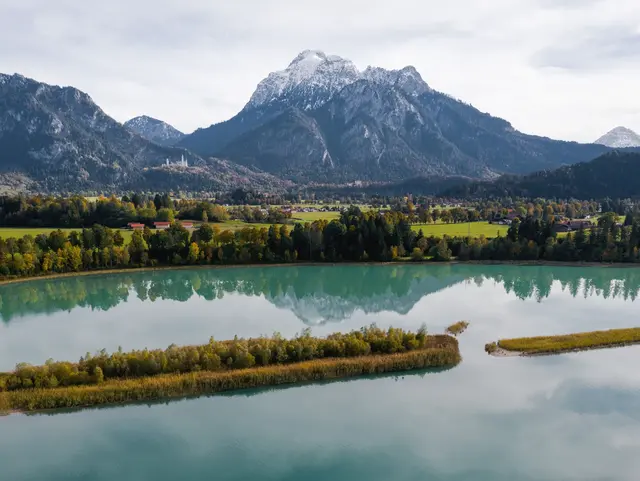 Türkisfarbener See mit Bergpanorama im südlichen Allgäu – traumhafte Naturkulisse für einen Urlaub auf dem Bauernhof.