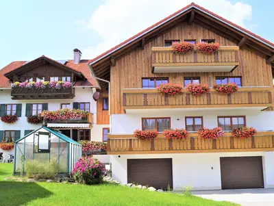 Ansicht auf Hof mit viel Blumen an den Balkonen. 